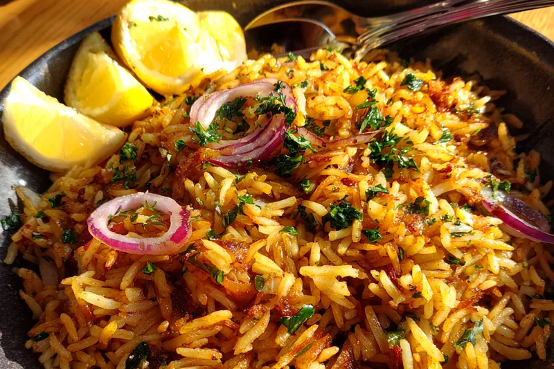 Chef Mitchell stirring a pot of Golden Butter Rice Delight on the stove.