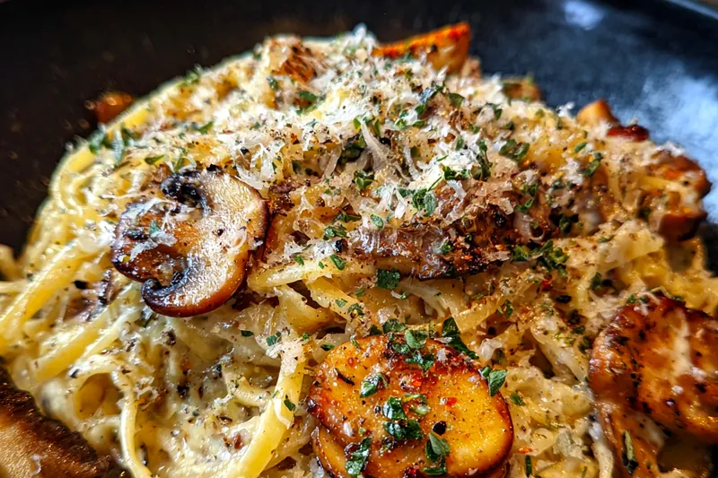 An arrangement of fresh ingredients for Mushroom Gruyere Pasta including mushrooms, pasta, and cheese.